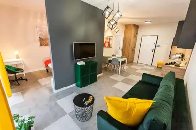 a living room with a green couch and a tv at Vintage Rakowicka Apartment in Kraków