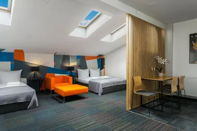 a hotel room with two beds and a desk at Premium Penthouse Apartment in Kraków