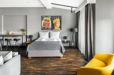 a bedroom with a bed and a yellow chair at Premium Penthouse Apartment in Kraków
