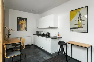 a kitchen with white cabinets and a table and chairs at Premium Penthouse Apartment in Kraków