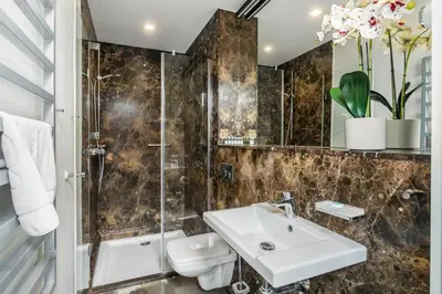 a bathroom with a sink and a toilet and a shower at Premium Penthouse Apartment in Kraków