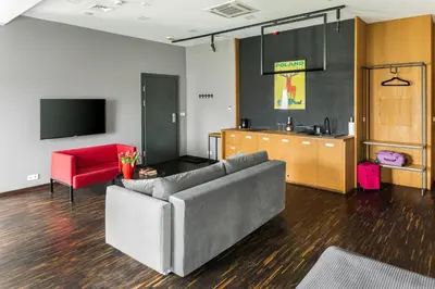 a living room with a couch and a red chair at Premium Penthouse Apartment in Kraków