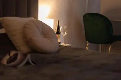 a hotel room with a chair and a wine glass at Kotlarska Apartments in Kraków