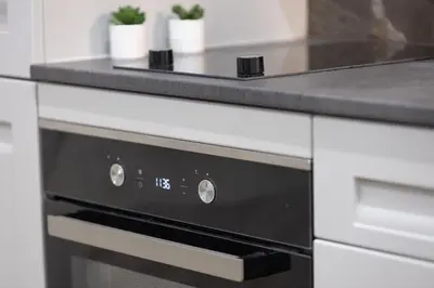 a kitchen with a black and white oven at Kotlarska Apartments in Kraków