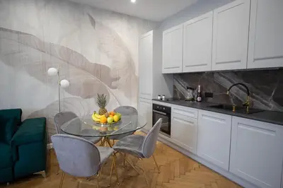 a kitchen with a table with a bowl of fruit on it at Kotlarska Apartments in Kraków