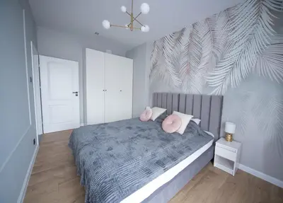 a bedroom with a bed with two pink pillows at Kotlarska Apartments in Kraków