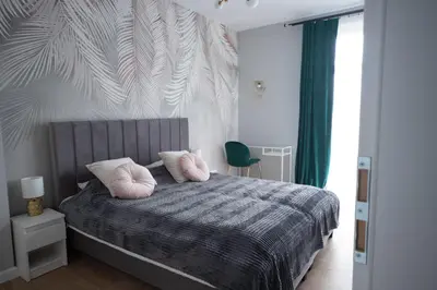 a bedroom with a bed with pink pillows on it at Kotlarska Apartments in Kraków