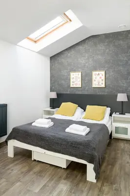 a bedroom with a large bed with two yellow pillows at Modern apartment in the very central location 18 in Kraków