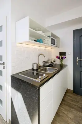 a kitchen with a sink and a black counter top at Modern apartment in the very central location 18 in Kraków