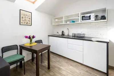 a kitchen with white cabinets and a table and a counter at Modern aparment in the very central location 19 in Kraków