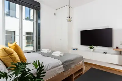 a bedroom with a bed and a flat screen tv at NovaNest Apartments - Kalwaryjska - by Upstairs in Kraków