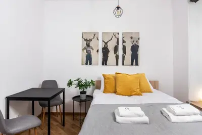 a bedroom with a bed with yellow pillows and a table at NovaNest Apartments - Kalwaryjska - by Upstairs in Kraków