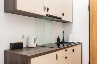a kitchen with white cabinets and a counter top at NovaNest Apartments - Kalwaryjska - by Upstairs in Kraków