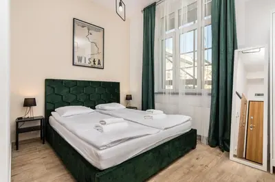 a bedroom with a large bed with a green headboard at NovaNest Apartments - Kalwaryjska - by Upstairs in Kraków