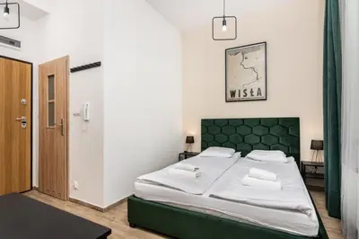 a bedroom with a large bed with a green headboard at NovaNest Apartments - Kalwaryjska - by Upstairs in Kraków
