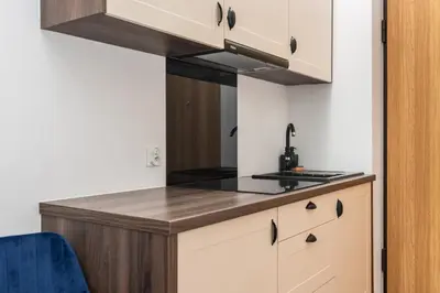 a kitchen with white cabinets and a counter top at NovaNest Apartments - Kalwaryjska - by Upstairs in Kraków