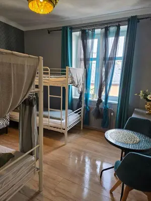 a room with two bunk beds and a table at LOTOS Hostel in Kraków