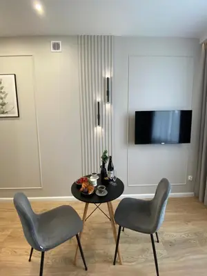 a living room with a table and two chairs at Green Residence Orawska 5 in Kraków