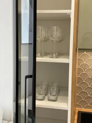 a row of wine glasses sitting on shelves at Green Residence Orawska 5 in Kraków