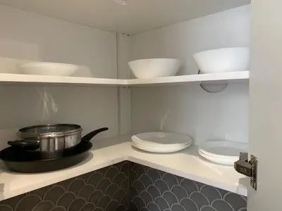 a kitchen with white dishes and a pot on a shelf at Green Residence Orawska 5 in Kraków