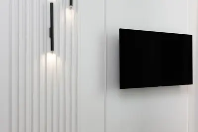 a flat screen tv on a white wall at Green Residence Orawska 5 in Kraków