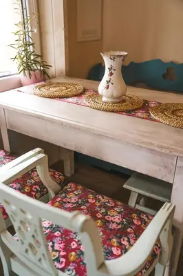 a table with two chairs and a vase on it at Ojcowski Zakątek-domek z balią oraz drewniany domek do wynajęcia in Wola Kalinowska