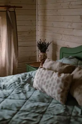 a bedroom with a bed and a vase with a plant at Ojcowski Zakątek-domek z balią oraz drewniany domek do wynajęcia in Wola Kalinowska