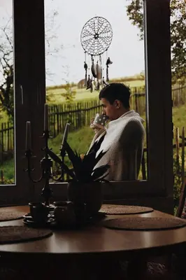 a man taking a picture in front of a window at Ojcowski Zakątek-domek z balią oraz drewniany domek do wynajęcia in Wola Kalinowska