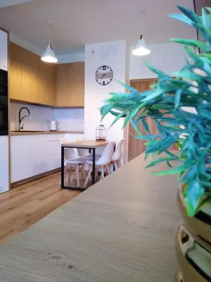 a kitchen and dining room with a table and a clock at Apartament Premium 72 in Zator