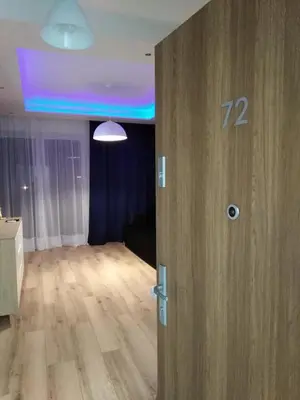 an open door to a living room with a blue ceiling at Apartament Premium 72 in Zator