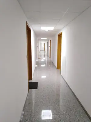 an empty hallway of an office building with white walls at Apartament Premium 72 in Zator