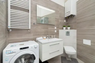 a bathroom with a washing machine and a sink at Perła Starego Miasta Kamienica Czapskich by Noclegi Renters in Kraków