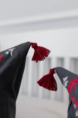 a person wearing a black cape with red tassels at Perła Starego Miasta Kamienica Czapskich by Noclegi Renters in Kraków