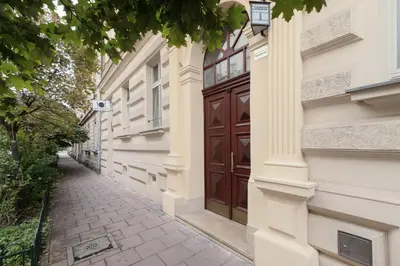 a building with a brown door and a sidewalk at Perła Starego Miasta Kamienica Czapskich by Noclegi Renters in Kraków