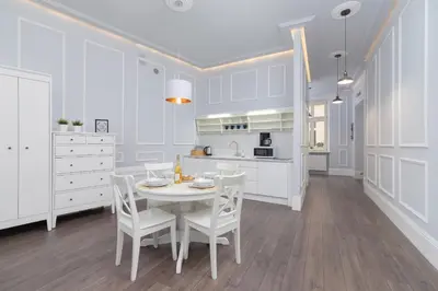 a white kitchen with a white table and chairs at Perła Starego Miasta Kamienica Czapskich by Noclegi Renters in Kraków