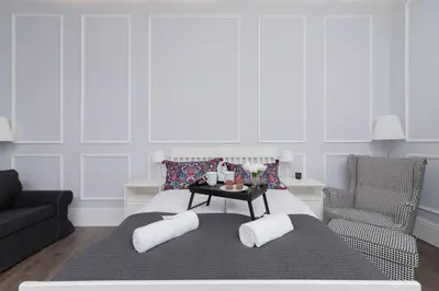 a bedroom with a bed with a table and a chair at Perła Starego Miasta Kamienica Czapskich by Noclegi Renters in Kraków