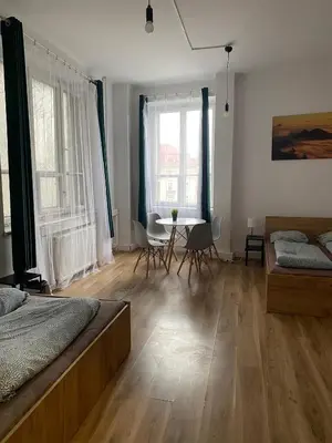 a bedroom with a bed and a table and chairs at Cracow Old Town Rooms in Kraków