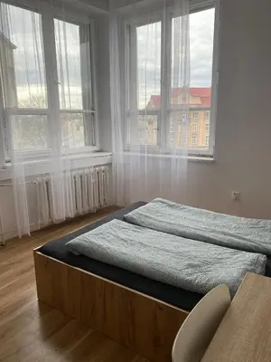a bed in a room with two windows at Cracow Old Town Rooms in Kraków