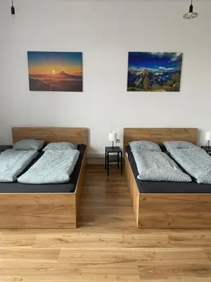 two beds in a room with wooden floors at Cracow Old Town Rooms in Kraków
