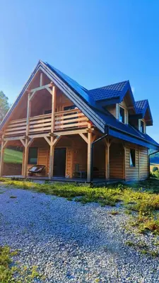 a large wooden house with a gambrel roof at Górska Ostoja in Sieniawa