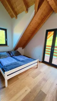 a bedroom with a bed in a room with wooden ceilings at Górska Ostoja in Sieniawa