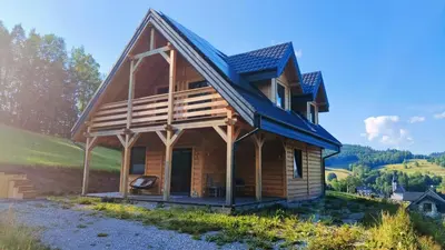 a house on a hill with a blue roof at Górska Ostoja in Sieniawa