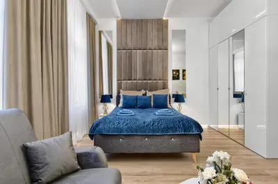 a bedroom with a blue bed and a couch at Silver Shine jacuzzi in Kraków