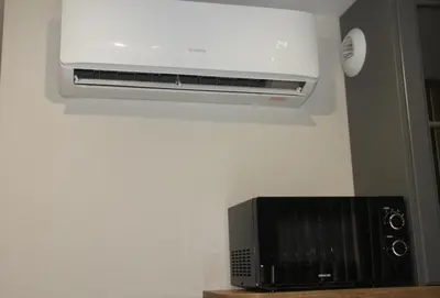 a microwave sitting on a wall next to a heater at NikoApartments - MiniApartment 2+2 in Kraków