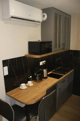 a kitchen with a table with chairs and a microwave at NikoApartments - MiniApartment 2+2 in Kraków