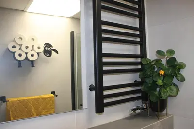 a bathroom with a mirror and a potted plant at NikoApartments - MiniApartment 2+2 in Kraków