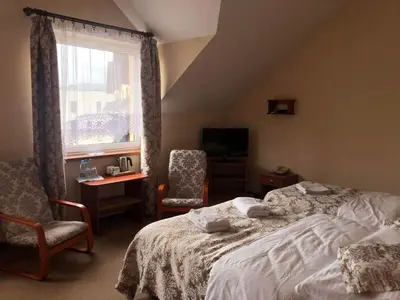 a bedroom with a bed and a chair and a window at MOTEL ZADOIL *** in Maków Podhalański