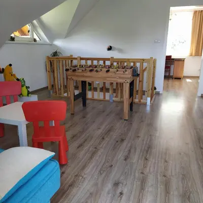 a room with a ping pong table and chairs at Leśny Domek in Las