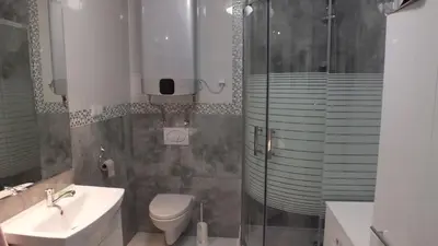 a bathroom with a shower and a toilet and a sink at Leśny Domek in Las