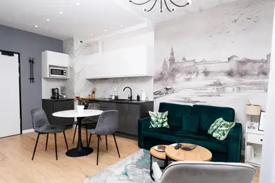 a living room with a green couch and a kitchen at krakow dream apartment in Kraków